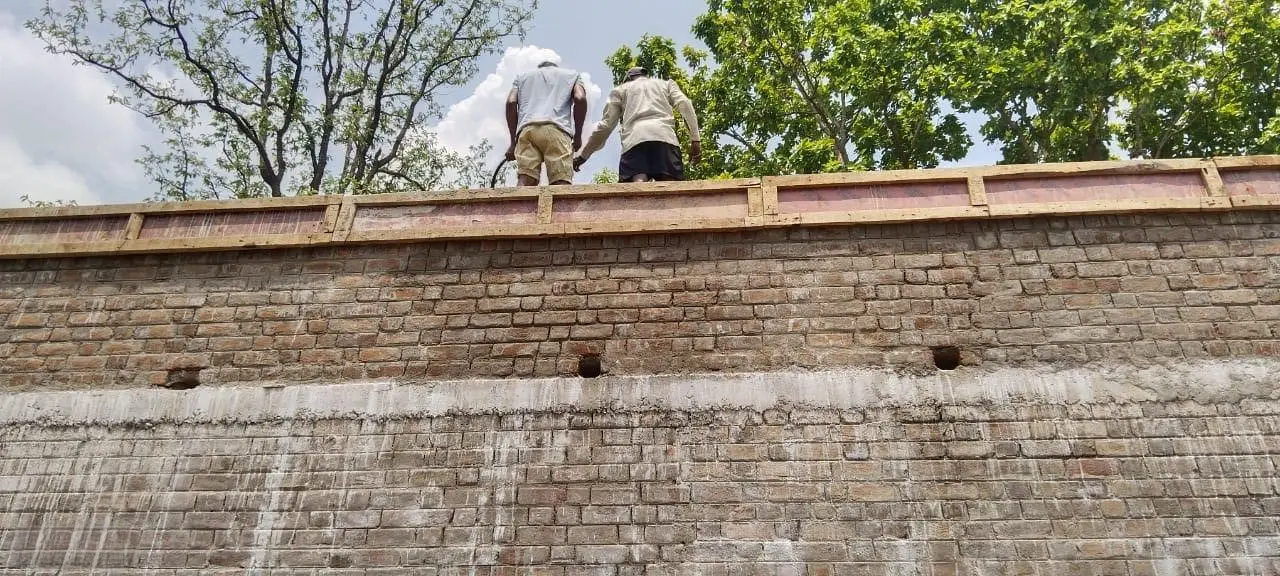 Workers atop the completed masonry walls at Forest Rest House